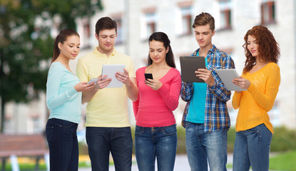 group of teenagers with smartphones and tablet pc