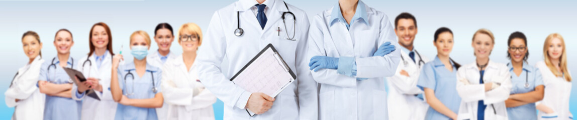 nurse and male doctor holding cardiogram - obrazy, fototapety, plakaty