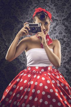 Vintage style - Woman using an old camera in polka dots clothes
