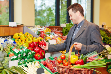 Man buying red pepper in supermarket