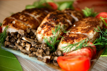 Breading chicken cutlets on a plate with dill cucumbers, tomatoe