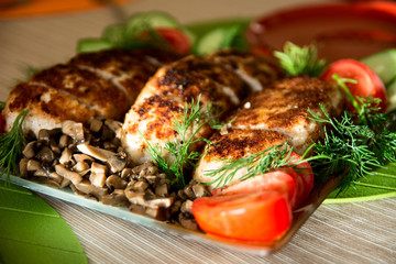 Breading chicken cutlets on a plate with dill cucumbers, tomatoe