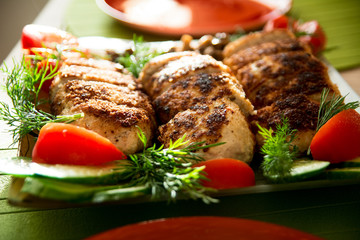 Breading chicken cutlets on a plate with dill tomatoes and cucum