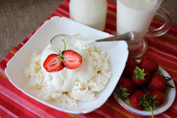 Dish of cottage cheese with cream and strawberries,