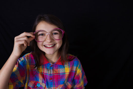 Smiling Happy, little girl, looking at camera wearing glasses.Close-up Studio Portrait