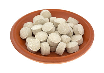 Obraz na płótnie Canvas Ginseng tablets in a small bowl