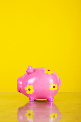 Piggy coin bank on yellow background 