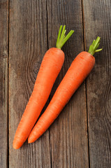 Fresh carrots on brown wooden background