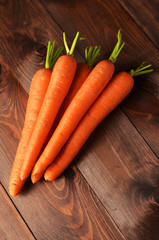 Fresh carrot on brown wooden background