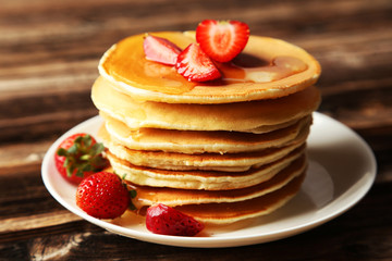 Delicious pancakes with strawberry on brown wooden background