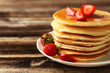 Delicious pancakes with strawberry on brown wooden background