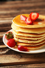 Delicious pancakes with strawberry on brown wooden background