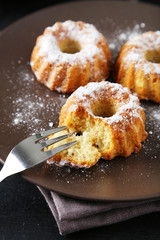 Bundt cakes on plate on black background