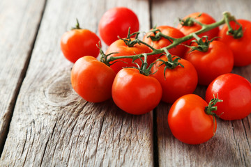 Fresh cherry tomatoes on grey wooden background