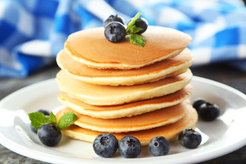 Delicious pancakes with blueberries on blue wooden background