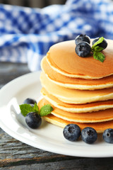 Delicious pancakes with blueberries on blue wooden background