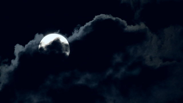 Eerie Full Moon Drifting Amid Dark Clouds
