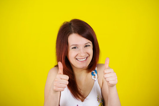 Happy surprised  young  woman very excited holding thumbs up