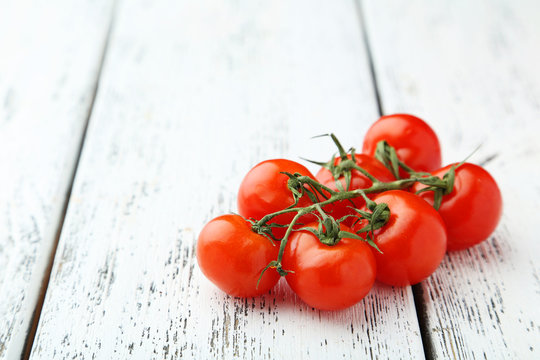 Fresh cherry tomatoes on white wooden background