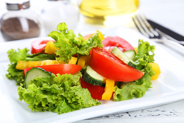 Fresh vegetable salad on white wooden background