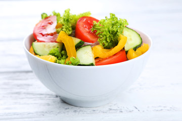Fresh vegetable salad on white wooden background