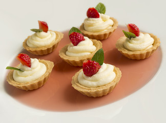 cupcakes with strawberry, whipped cream, jelly and mint