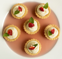 cupcakes with strawberry, whipped cream, jelly and mint