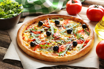Fresh tasty pizza on brown wooden background