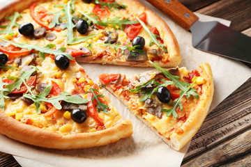 Fresh tasty pizza on brown wooden background