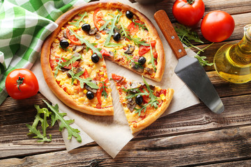 Fresh tasty pizza on brown wooden background