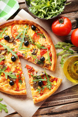 Fresh tasty pizza on brown wooden background