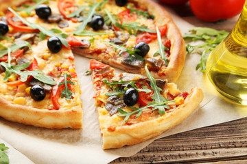 Fresh tasty pizza on brown wooden background
