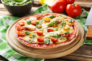 Fresh tasty pizza on brown wooden background