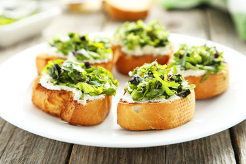 Tasty fresh bruschetta on plate on grey wooden background