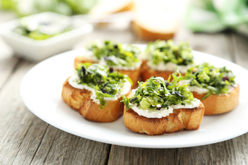 Tasty fresh bruschetta on plate on grey wooden background