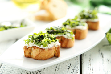 Fototapeta na wymiar Tasty fresh bruschetta on plate on white wooden background