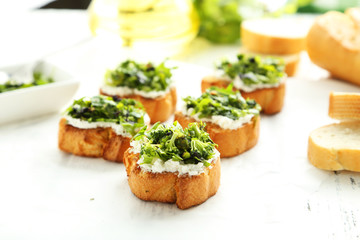 Tasty fresh bruschetta on parchment on white wooden background