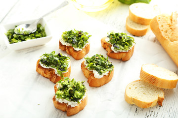 Tasty fresh bruschetta on parchment on white wooden background