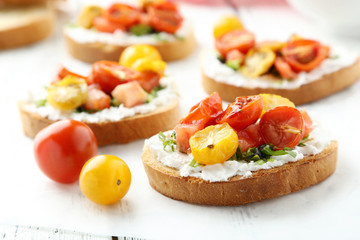 Tasty fresh bruschetta with tomatoes on white wooden background