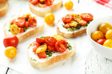 Tasty fresh bruschetta with tomatoes on white wooden background