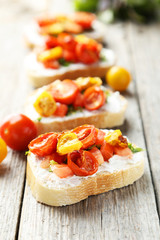 Tasty fresh bruschetta with tomatoes on grey wooden background