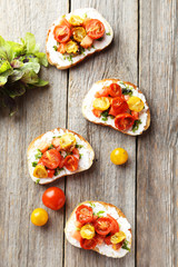 Tasty fresh bruschetta with tomatoes on grey wooden background