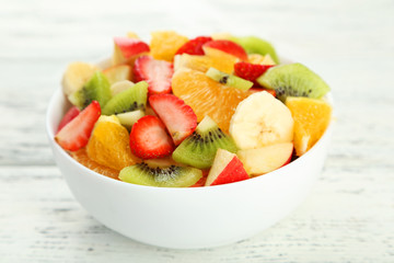 Fresh fruit salad on white wooden background