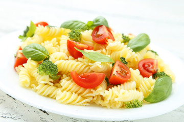 Delicious pasta on plate on white wooden background
