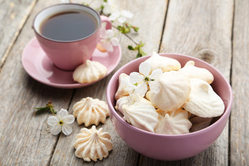 French meringue cookies in bowl on grey wooden background
