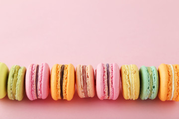 French colorful macarons on pink background
