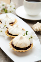 French meringue cookies in tartlet on plate on grey wooden backg