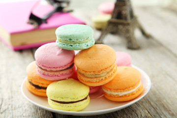 French colorful macarons on plate on grey wooden background