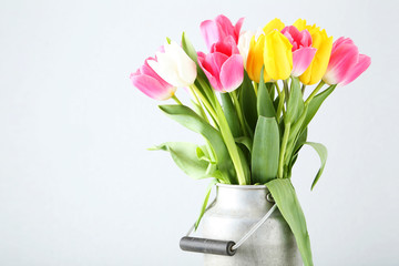 Beautiful tulips in can on white background