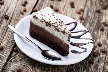 Chocolate dessert with coffee cup and coffee beans on wooden bac